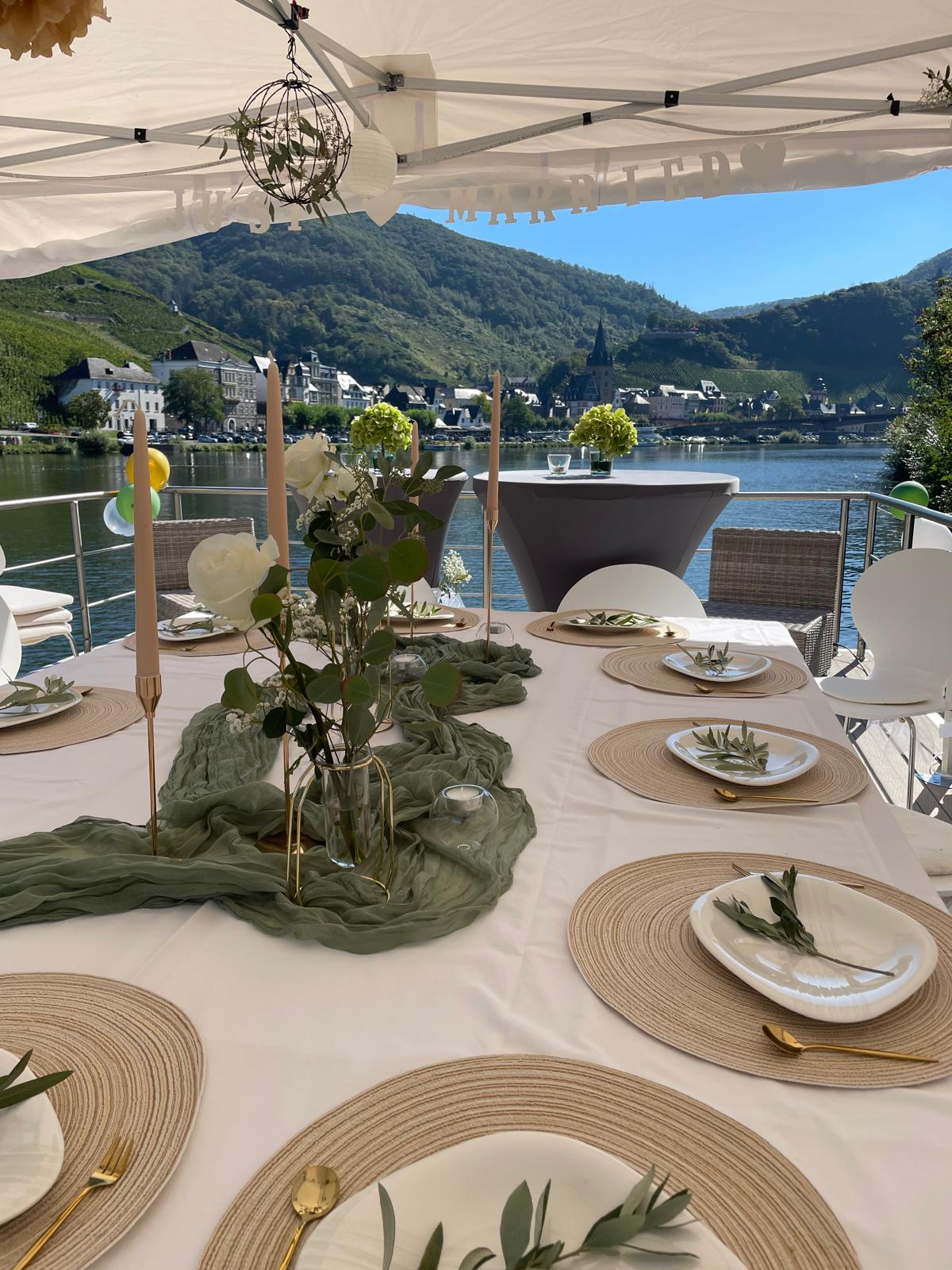 Gedeckte Tafel auf dem Sonnendeck der SOLEJO mit Blick auf Bernkastel-Kues und die Mosel