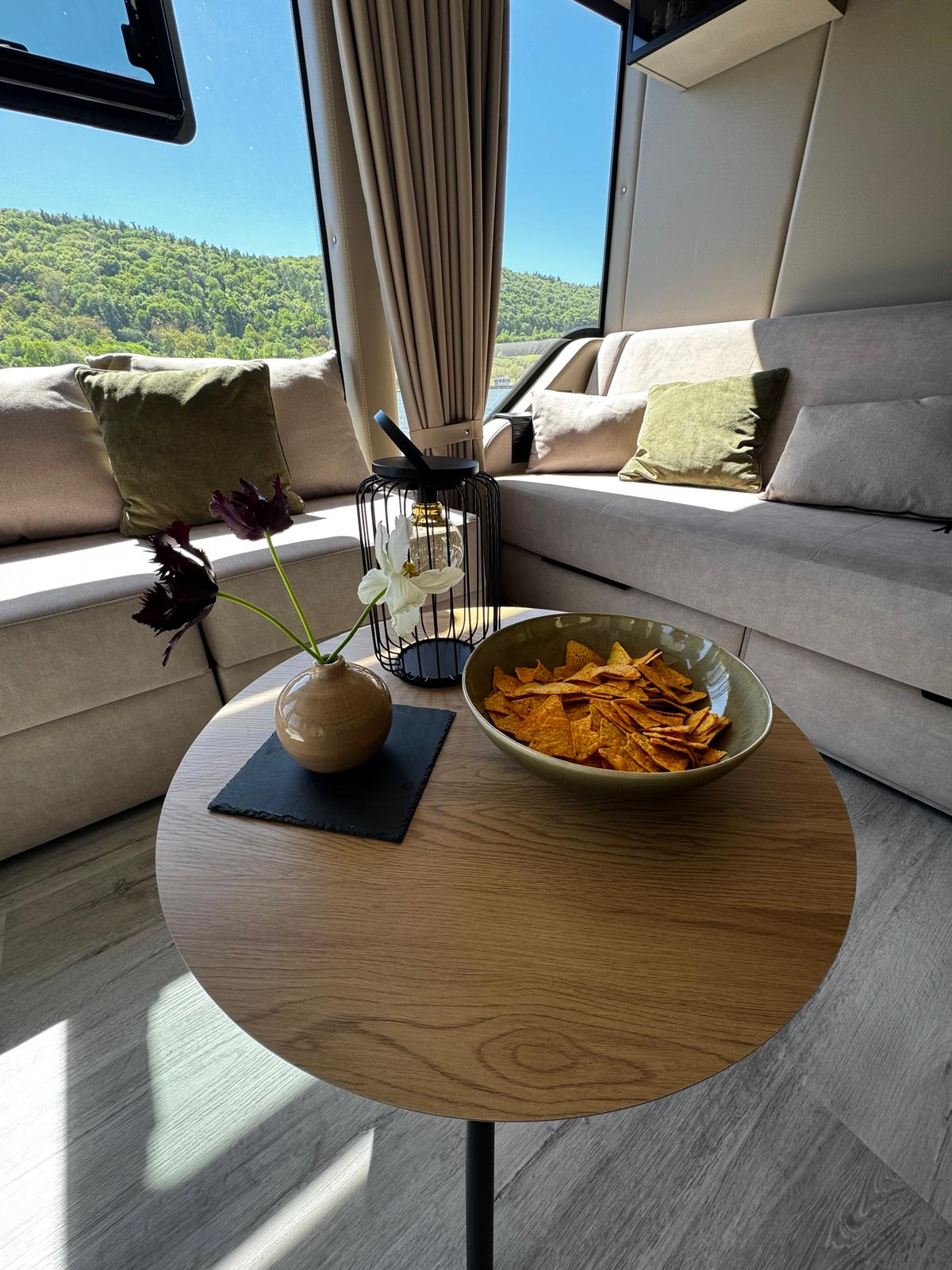 Lounge-Ecke mit runden Couchtisch im Sonnenlicht