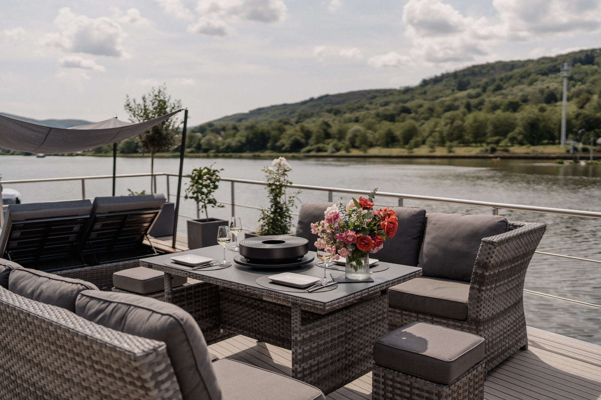 Gedeckter Tisch und Lounge auf dem Sonnendeck der SOLEJO mit Blick auf die Mosel
